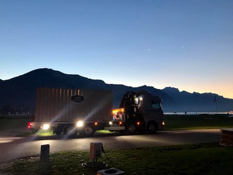 camion avec container stand evenementiel sur le bord du lac d'annecy au petit matin avec les lumieres de la nuit