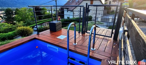 piscine container vue sur la terrasse bois et le skimmer autour une barriere de securite