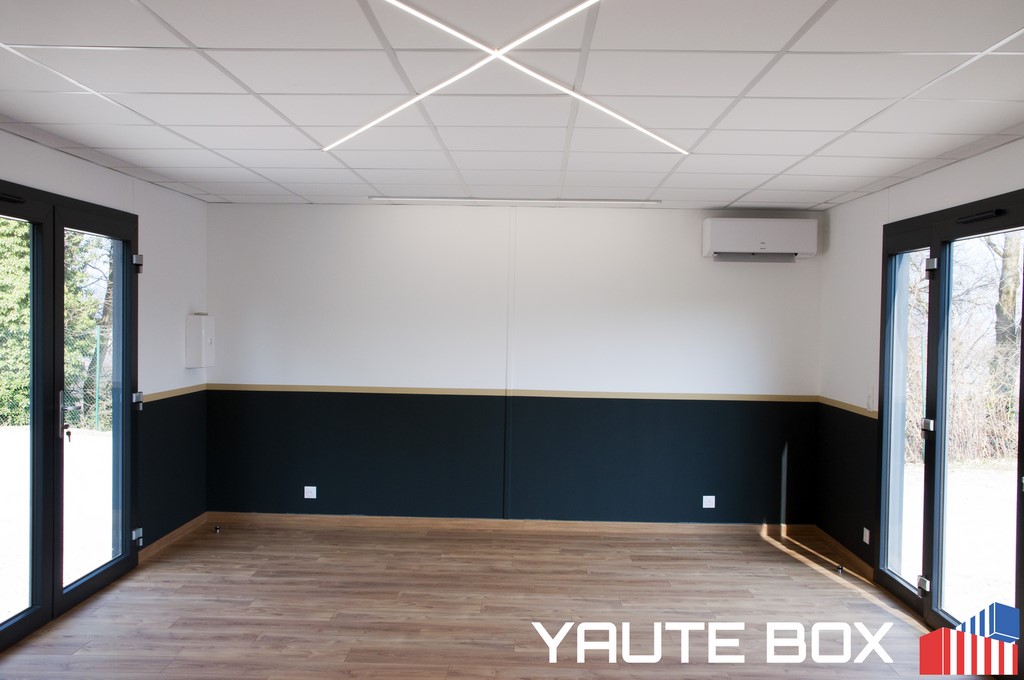 interieur du container ecole parquet bois stratifié mur blanc avec soubassement noir et liseré or