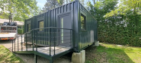 container cuisine yaute box vue de l'exterieur 3 containers assemblés avec une rampe d'accés le tout installé dans un parc au printemps et de couleur griis anthracite