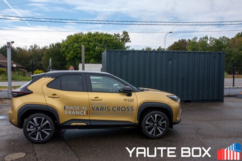 vue sur toyota yaris cross à sa sortie devant un container evenmentiel gris anthracite