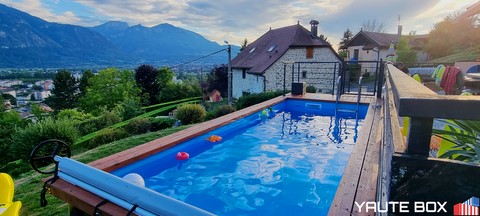 piscine container vue sur les montagnes depuis la piscine bleu et margelle bois hors sol
