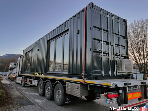container école en livraison sur camion remorque sanglé