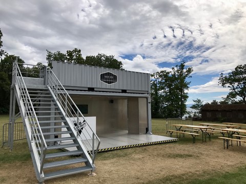 container avec vue de coté pour evenement  table et banc disposé à coté